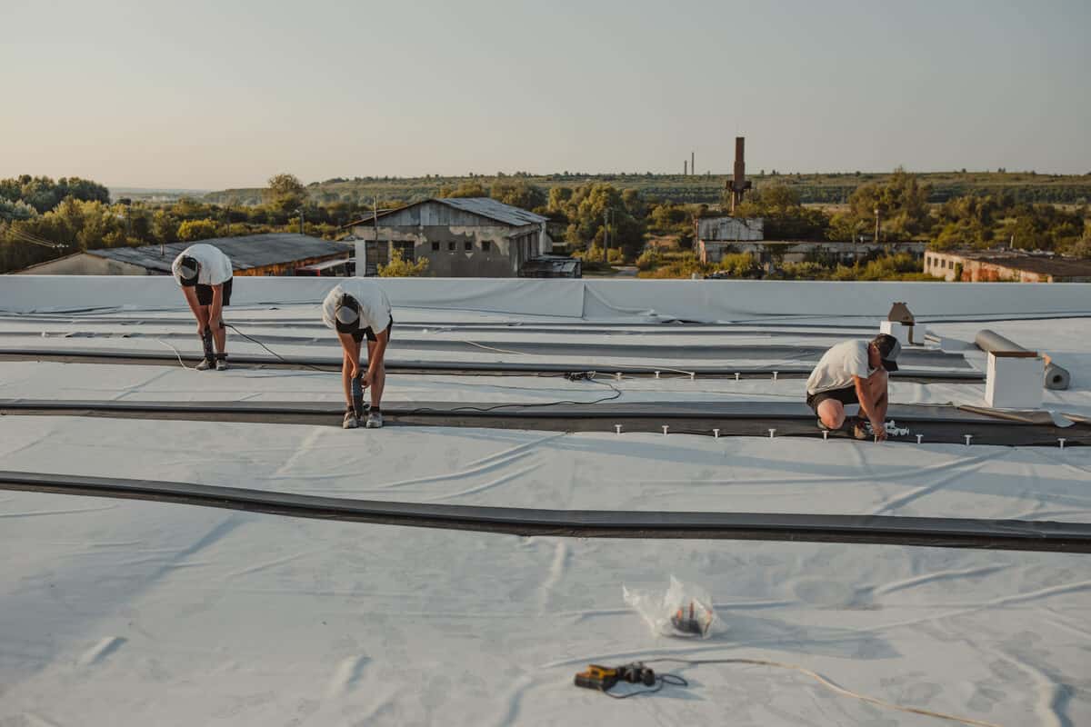 Commercial roofing crew inspecting a flat roof